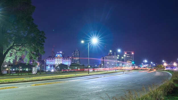 Light trails in a curve with a city in the background