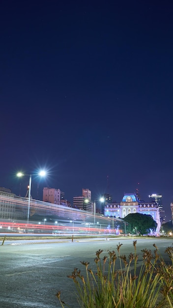 Light trails in a curve with a city in the background