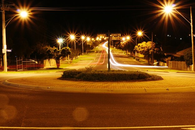 Foto tracce di luce su una strada illuminata di notte