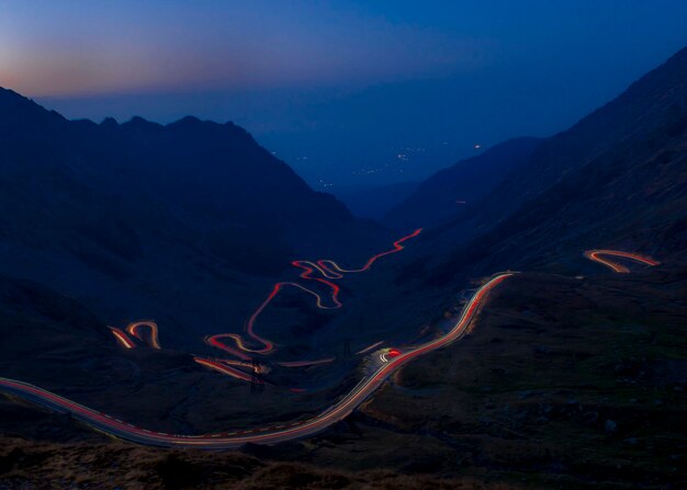 Light trails on mountain against sky at night