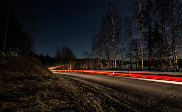 Фото Светлые следы на дороге на фоне ночного неба