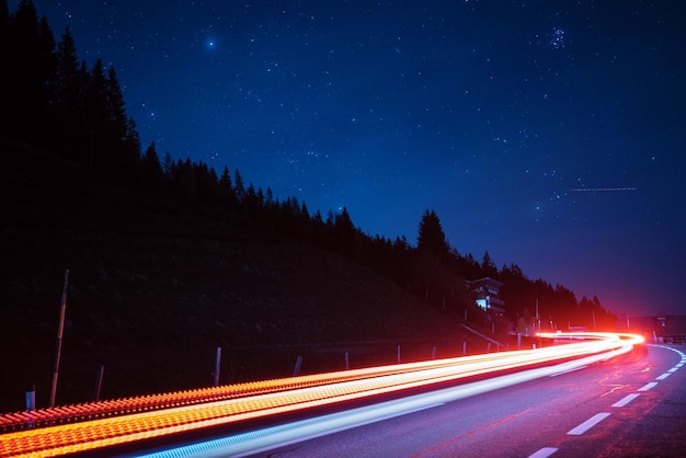 明るい夜の空に照らされた道路の光線