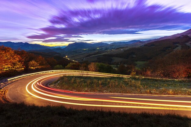 Light trails on road against sky at night