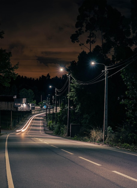 Light trails on road against sky during sunset
