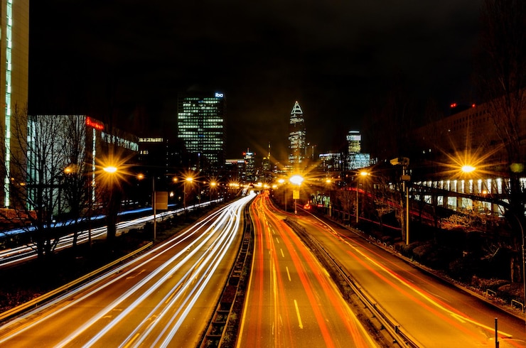 Photo light trails on road amidst buildings in city at night