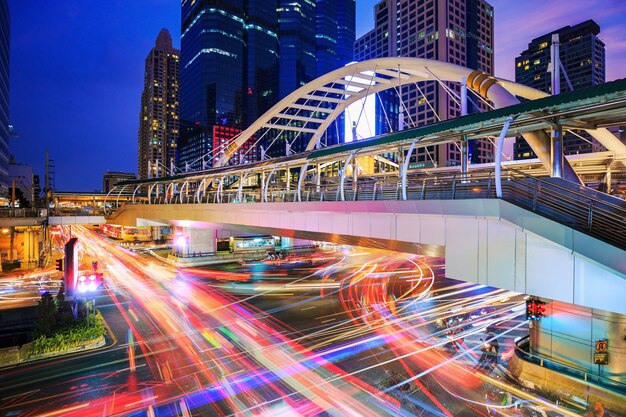 Light trails on road amidst buildings in city at night