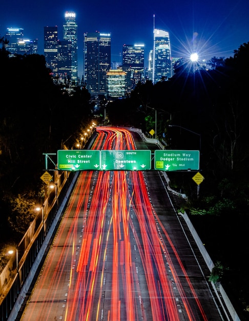 Photo light trails on road amidst buildings in city at night