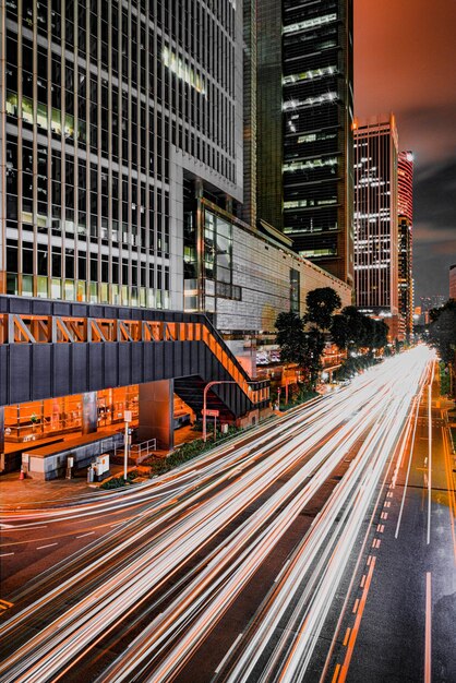 Photo light trails on road by buildings in city at night