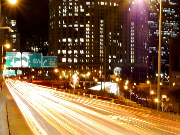 Light trails on street against building at night