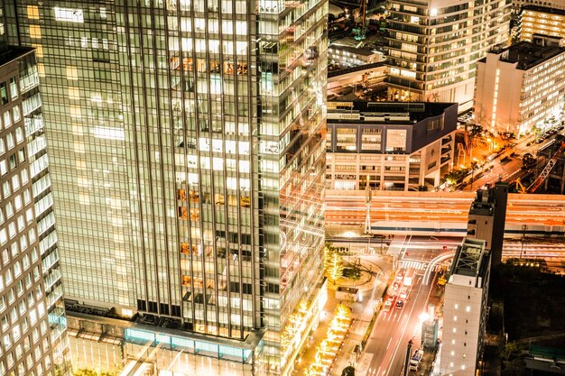 Photo light trails on street amidst buildings in city at night