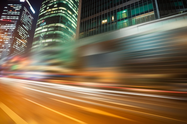 Foto sentieri di luce sulla strada tra gli edifici di notte