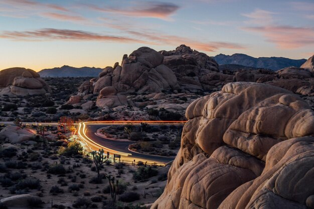 Photo light trails on street amidst rock formations