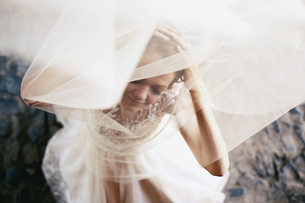 Фото Светлая вуаль охватывает мечтательную невесту, ставящую на тротуар