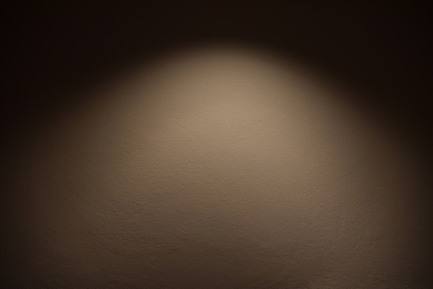 Light on wall - the lamp shines with warm light on brown wall / light effect