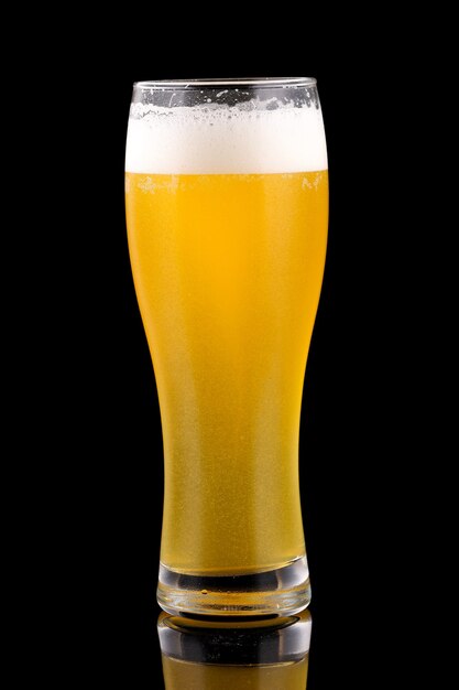 Light wheat beer in a tall glass black surface