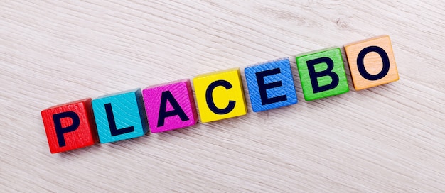 On a light wooden surface on multi-colored bright wooden cubes the word PLACEBO