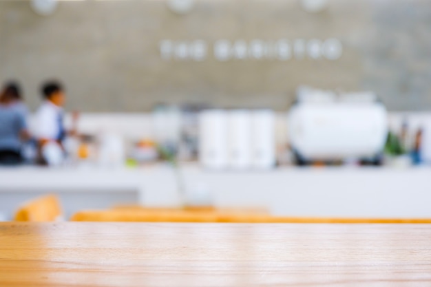 Light wooden top table in front of blurred background of cafe or coffee shop 