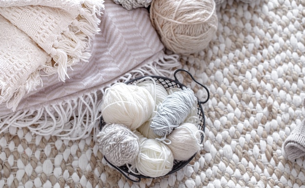 Light yarn for knitting in a basket with knitted elements.