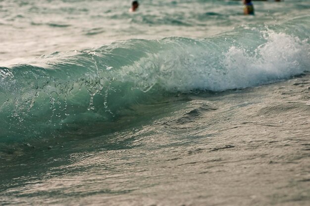 Photo lightblue wave disintegrating on drops moves toward a shore