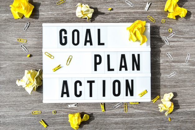 Foto lightbox met tekst goal plan action op houten