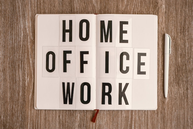 Foto lightbox met tekst home office work met notitieboekje en pen