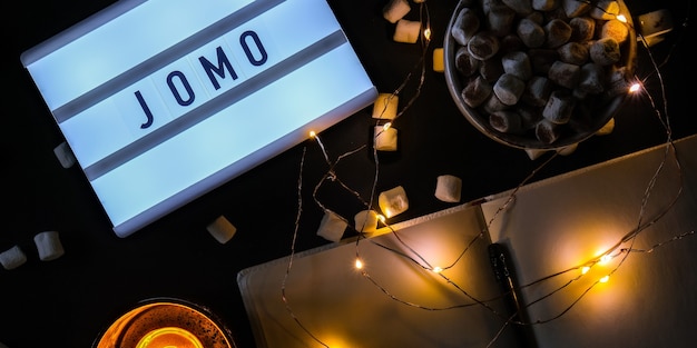 Lightbox met tekst jomo vreugde om het concept van ontspanning te missen, van informatie en gadgets tot...