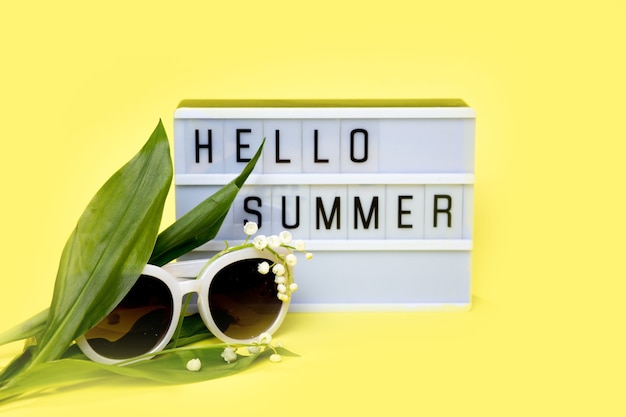 Foto lightbox con messaggio hello summer su sfondo giallo. concetto di estate, viaggio, vacanza.