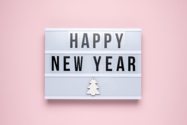 파스텔 핑크 배경에 HAPPY NEW YEAR라는 텍스트가 있는 라이트박스