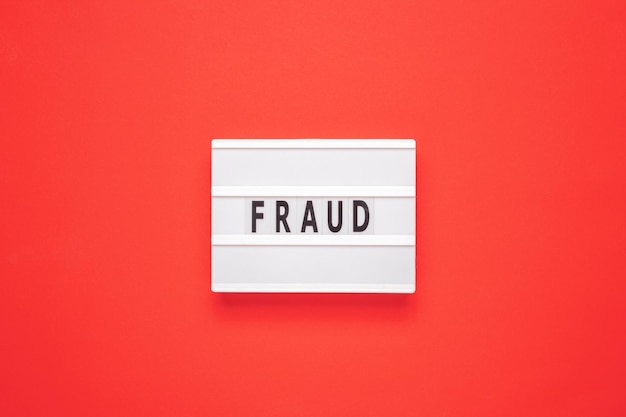 Lightbox with word fraud on red background Business concept