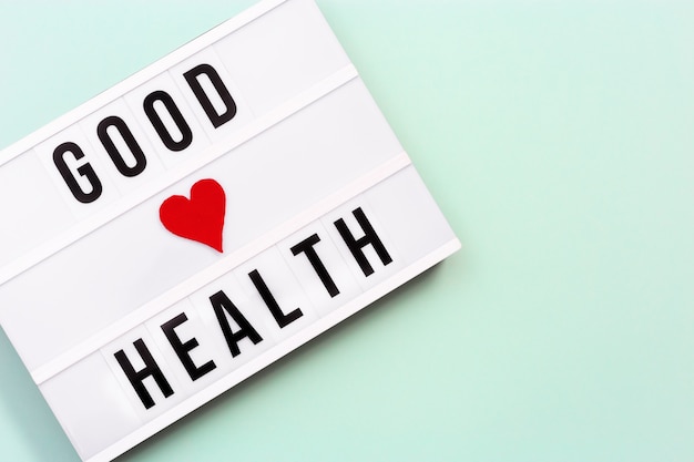 写真 青い色の背景にgoodhealthという言葉が書かれたライトボックス健康と医療の概念のケア