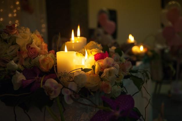 Photo lighted candles on a wedding table bride and groom in a restaurant.