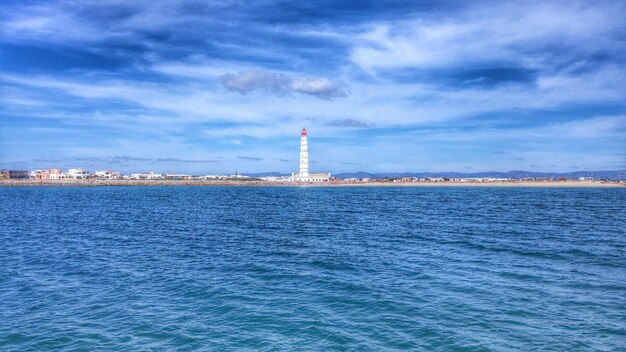 Lighthouse against sky seen from sea