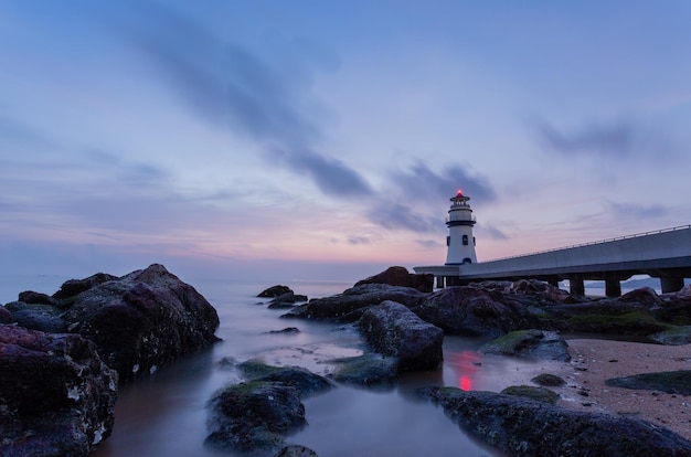 写真 海の中の灯台と空に照らされた建物