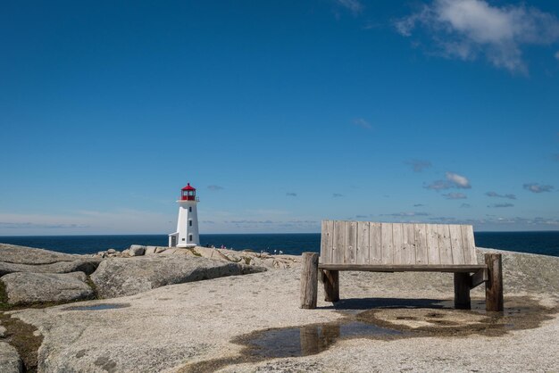 Foto faro sulla spiaggia contro il cielo blu