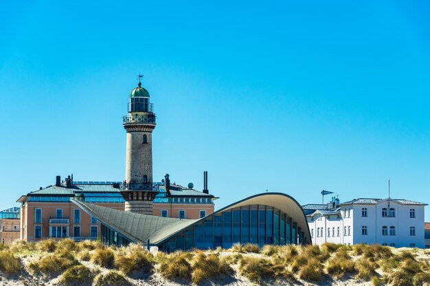 Lighthouse on beach against clear blue sky