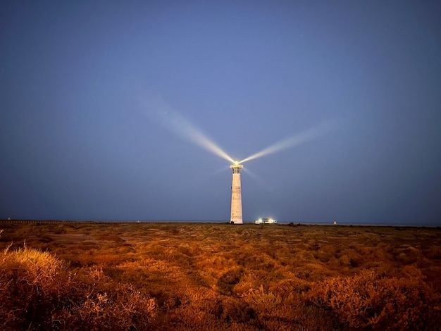 Photo lighthouse by sea against clear sky