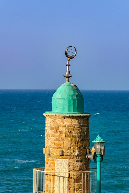 写真 晴れた空に照らされた海の灯台