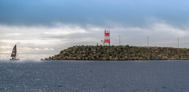 Foto faro dal mare contro il cielo