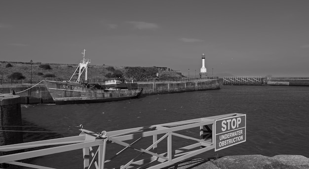 Photo lighthouse by sea against sky