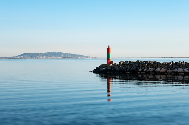 Lighthouse by sea against sky