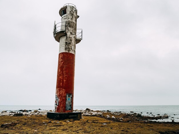 Foto faro dal mare contro il cielo