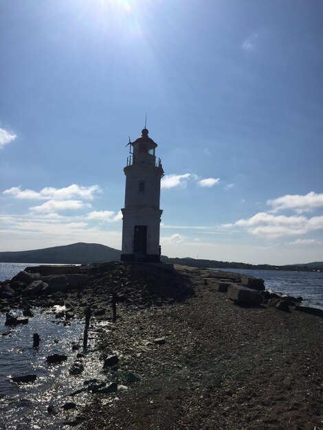 Foto faro dal mare contro il cielo