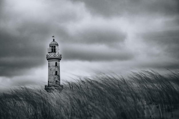 Photo lighthouse by sea against sky