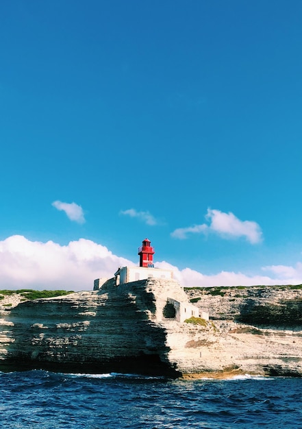 Foto faro dal mare contro il cielo