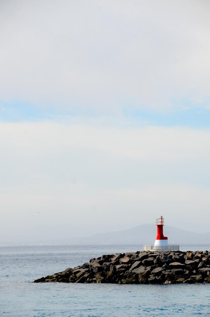 Foto faro dal mare contro il cielo