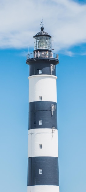 Photo lighthouse by sea against sky