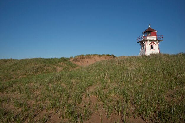 Lighthouse at coast, north shore, prince edward island national\
park, prince edward island, canada
