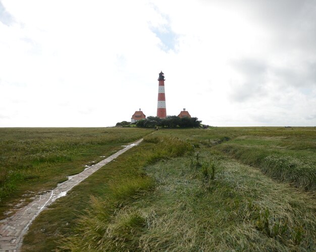 Foto faro sul campo contro un cielo nuvoloso