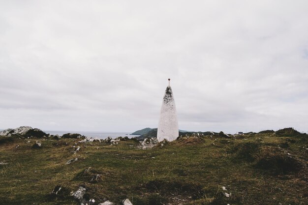 Foto faro sul campo contro un cielo nuvoloso