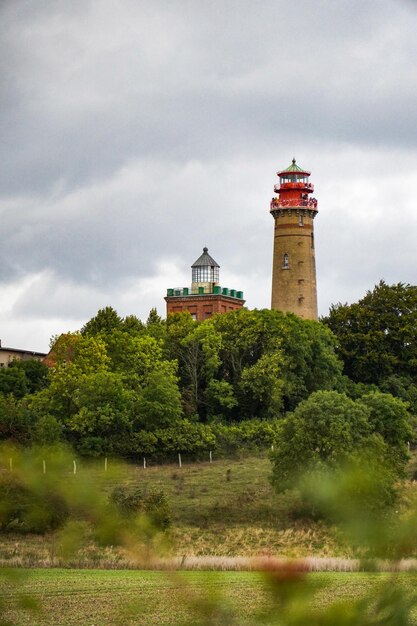 Lighthouse on field against sky